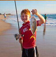 Young man hold up fish caught in Buxton NC National Seashore.