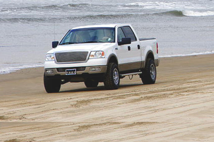 New Ford truck driving on beach at the Buxton NC NPS National Seashore.